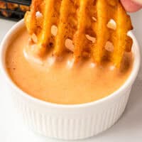 waffle fry being dipped in a bow of copycat chick fil a sauce with recipe name at the bottom