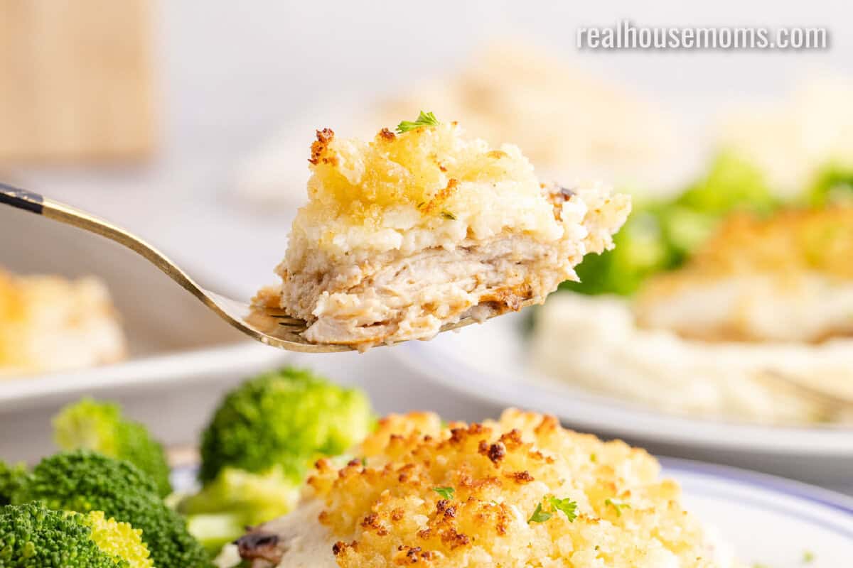 bite of Copycat Longhorn Parmesan Crusted Chicken over the plate