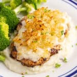 square image of copycat longhorn parmesan crusted chicken served over mashed potatoes with a side of broccoli