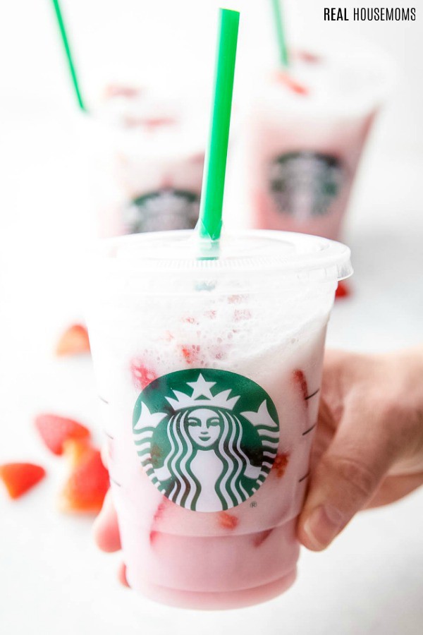 hand holding a copycat starbucks pink drink in a cup with lid and straw