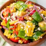 square image of corn salad in a wooden serving bowl