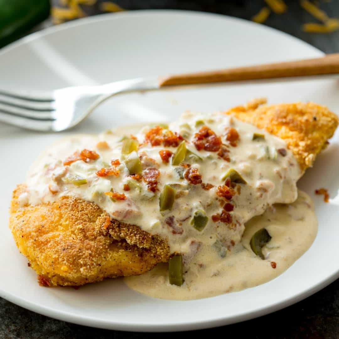 Cornbread Crusted Chicken with Bacon Jalapeno Popper Sauce is an easy to make dinner that's packed with flavor and is sure to become your new favorite meal!