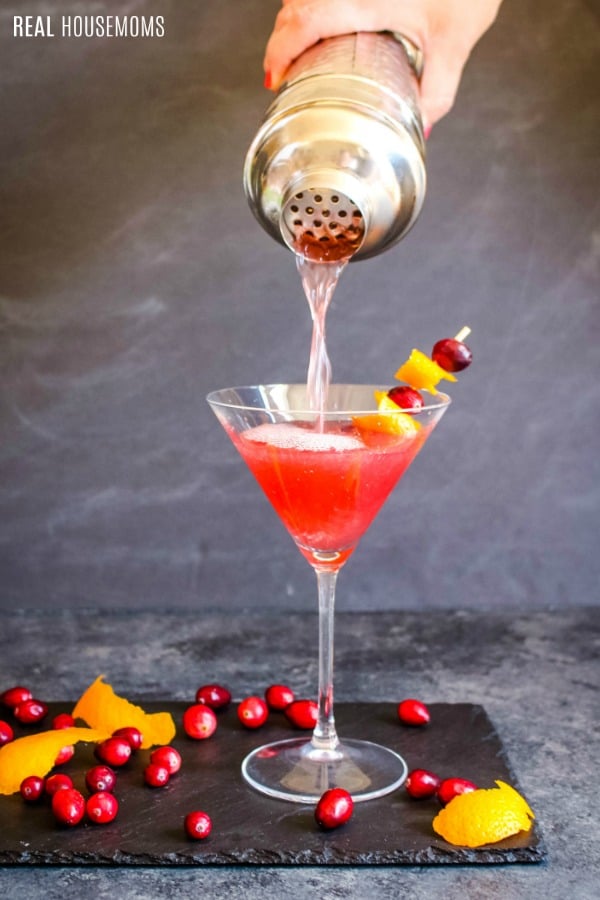 cosmopolitan cocktail being pour from a cocktail shaker into a martini glass
