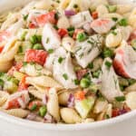 square close up image of crab pasta salad in a serving bowl