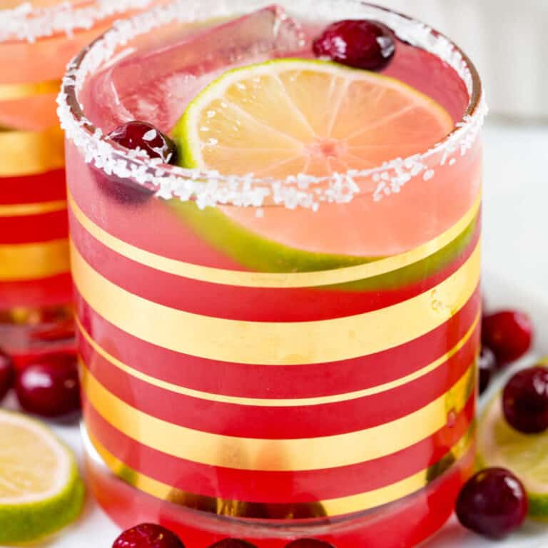 square image of cranberry margarita in a rocks glass with salt rim
