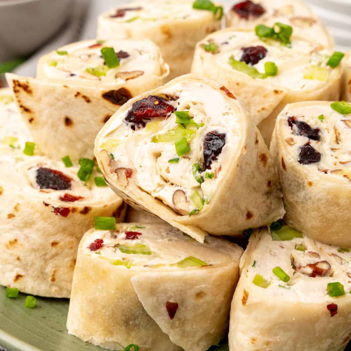 square close up image of cranberry pecan chicken salad pinwheels on a plate