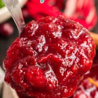 close up of a spoonful of cranberry sauce with orange and cinnamon over the serving bowl with the title of the post on top of the image in black and blue lettering