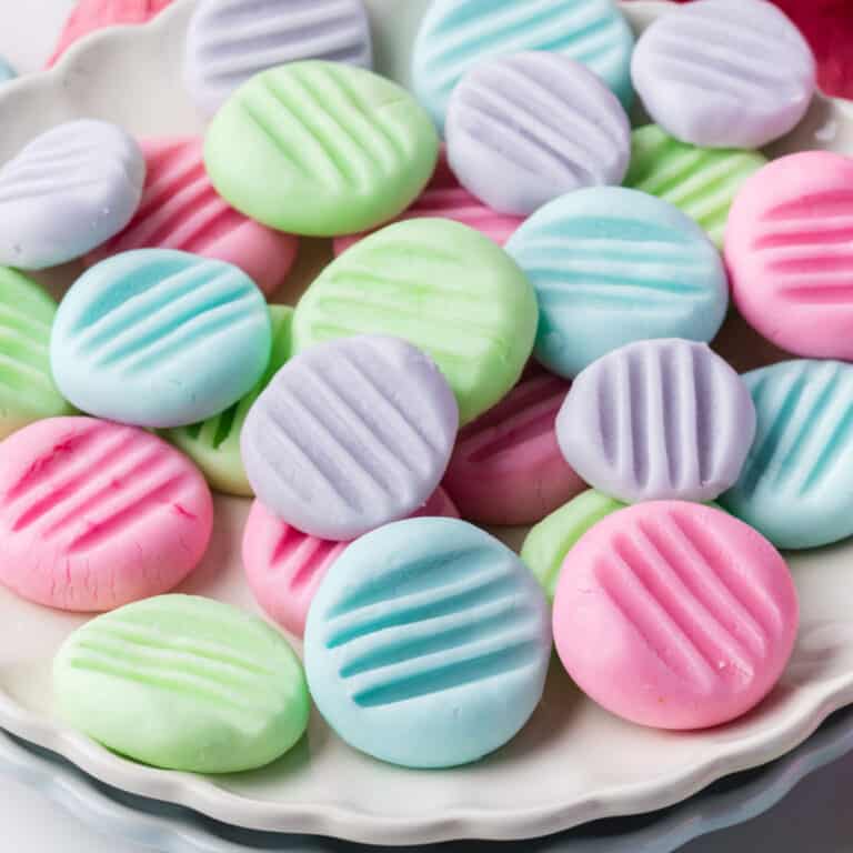 square image of pastel cream cheese mints on a white plate