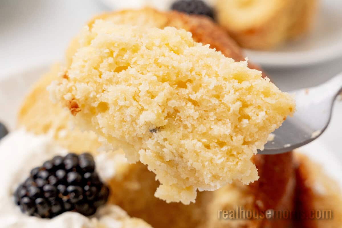 close up of a bite of cream cheese pound cake on a fork over the plate