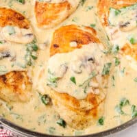 looking down into a skillet of creamy chicken florentine with recipe name at bottom