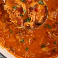 ladel of creamy chicken tortilla soup over the pot with recipe name at bottom