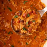 square image of a ladle of creamy chicken tortilla soup over the pot