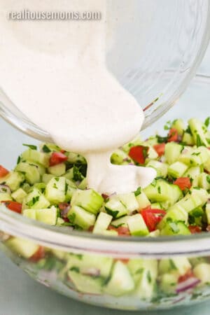 dressing being poured over cucumber salsa mixture