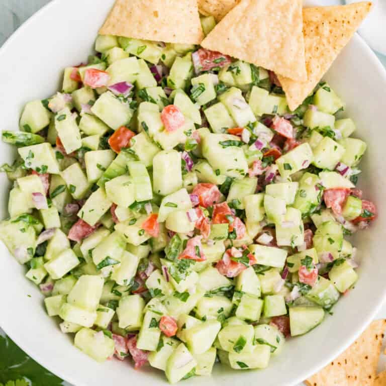 square image of creamy cucumber salsa in a white serving bowl with tortilla chips