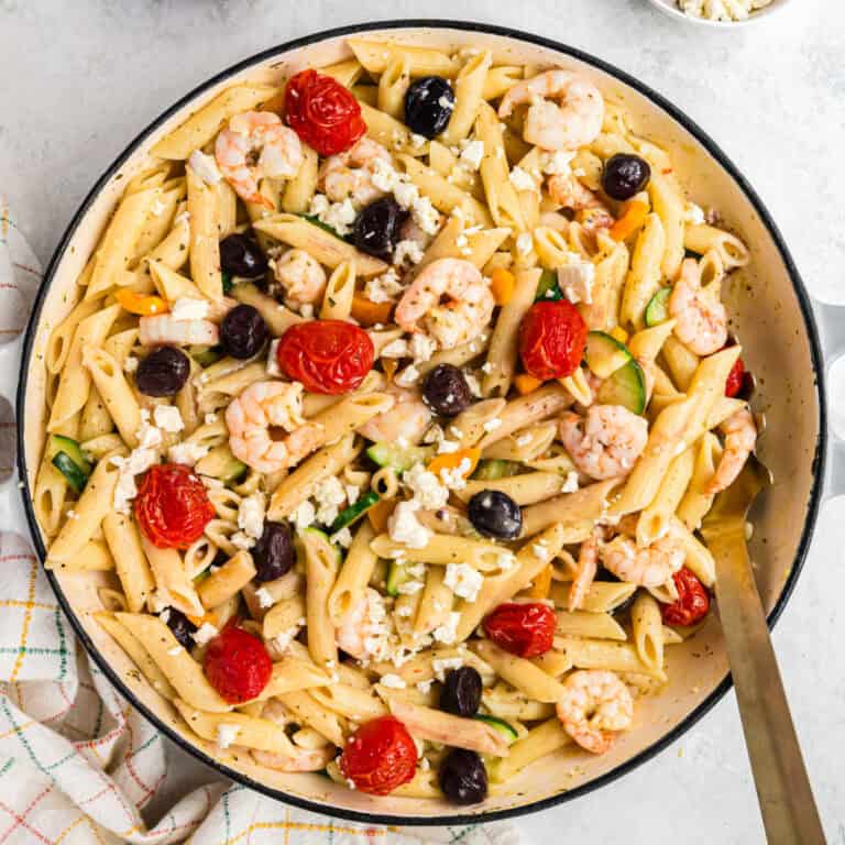 square image of creamy greek shrimp pasta in a dutch oven