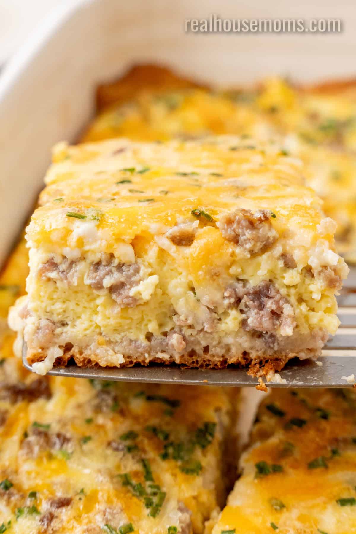 slice of crescent roll breakfast casserole on a metal spatula over the baking dish