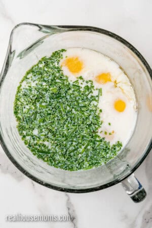 eggs, milk, chives, salt, and garlic powder in a large glass mixing bowl