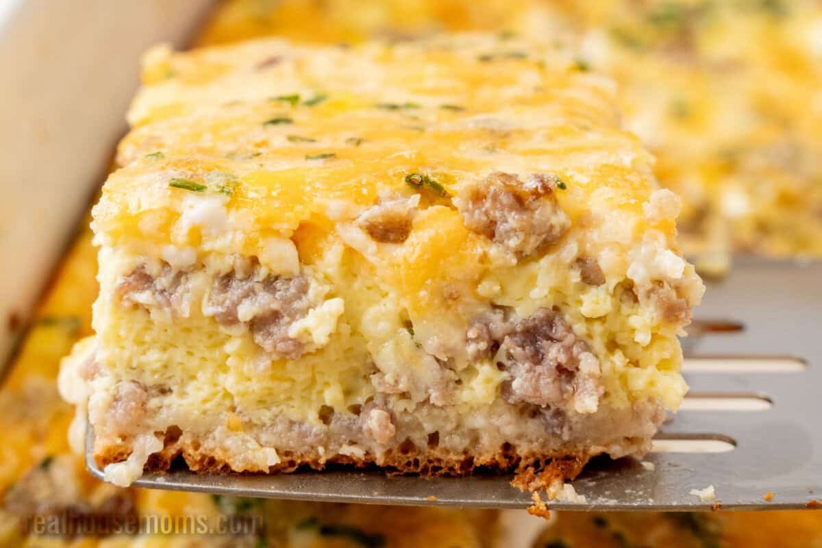 slice of crescent roll breakfast casserole on a spatula over the baking dish