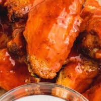 crispy baked chicken wings tossed in buffalo sauce with recipe name at the bottom