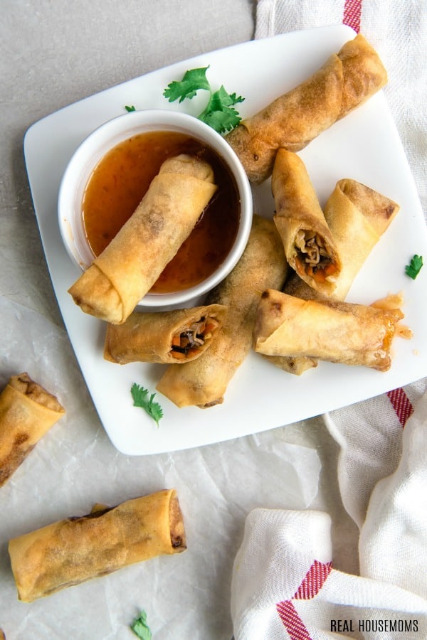 crispy spring roll on a serving plate with dipping sauce