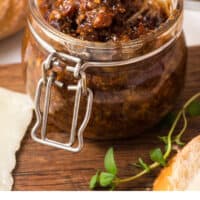 spoonful of crock pot bacon jam being lifted from the jar with recipe name at the bottom