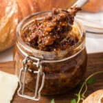 square image of a spoonful of crock pot bacon jam being lifted from the jar