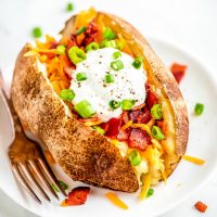 Crock Pot Baked Potatoes are the easiest way to cook a potato! Wrap them in foil & toss in the slow cooker for a delicious side that'll be ready for dinner!