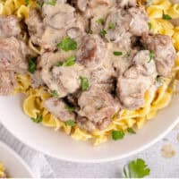 crock pot beef stroganoff served over egg noodles with recipe name at the bottom