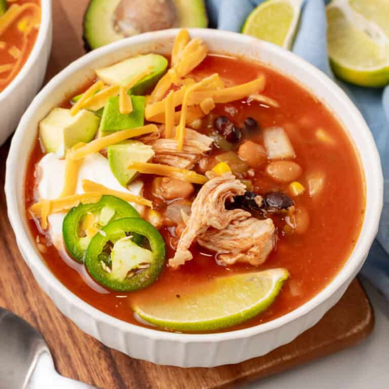 square image of a bowl of crock pot black bean & chicken soup with garnished on top