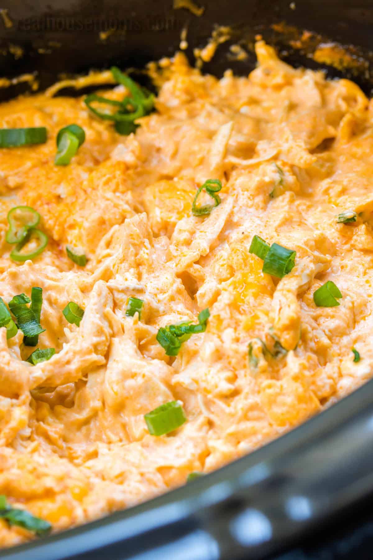 angled view of Crock Pot Buffalo Chicken Dip in a black slow cooker