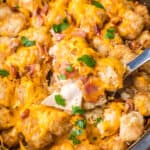 square image of a spoonful of crock pot cheesy chicken, bacon & tater tot bake over the slow cooker