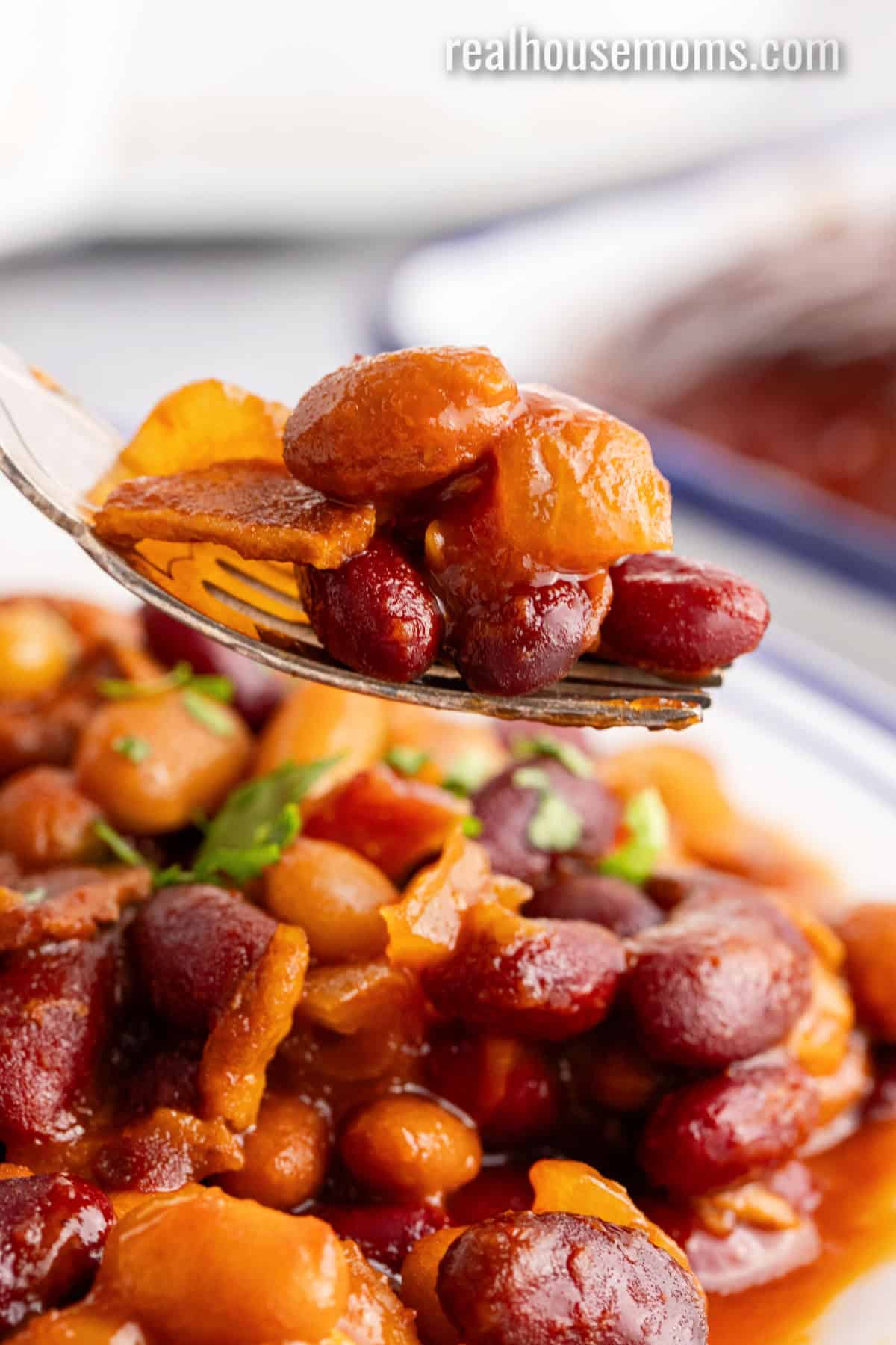 forkful of crock pot baked beans over the plate