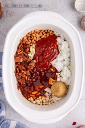 baked beans ingredients added to a slow cooker crock