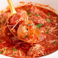 square image of crockpot meatballs on a serving spoon over the slow cooker