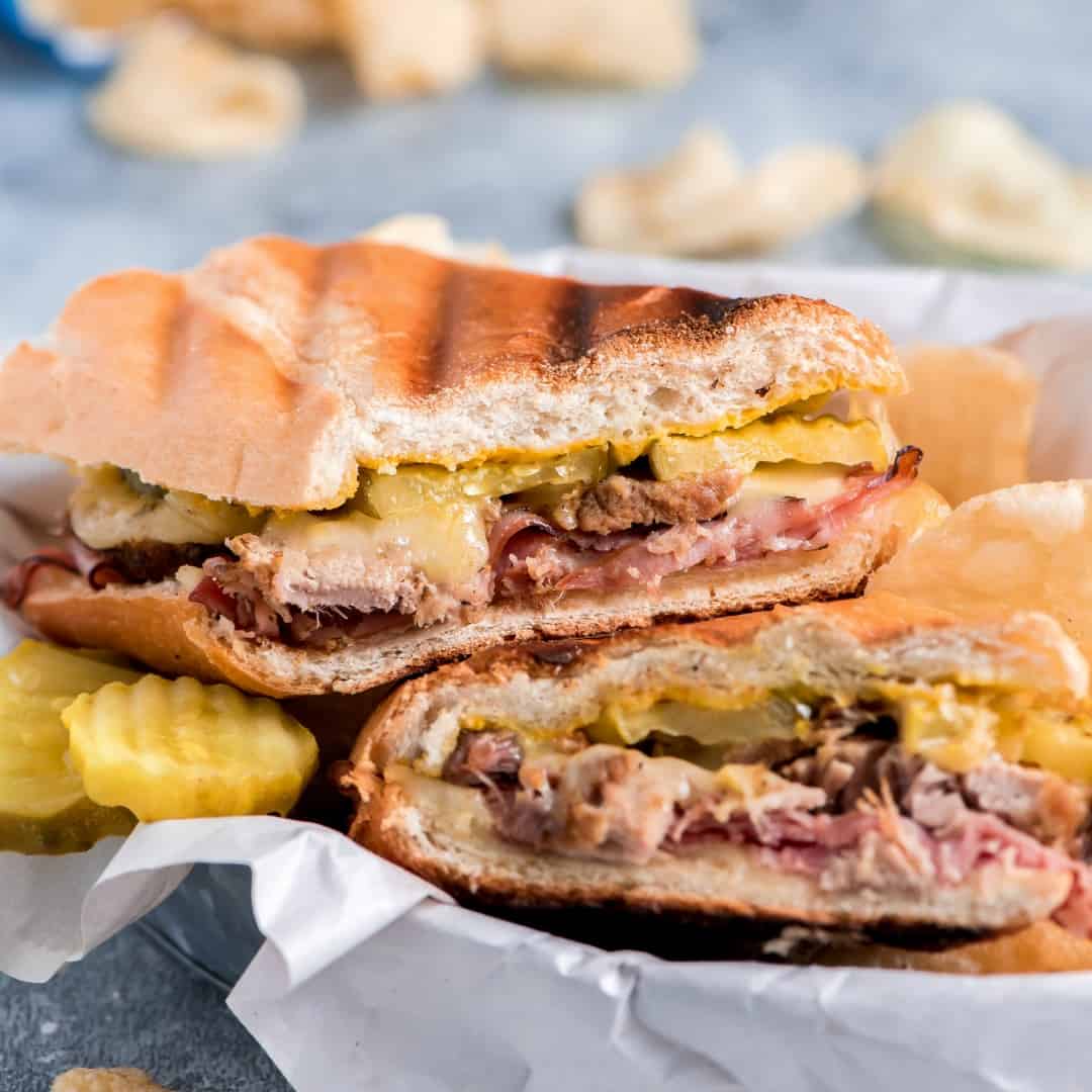 Take your sandwich game to the next level with this pork and cheese loaded hot Cuban Sandwich Recipe. With grilled crispy bread, melted cheese, and flavorful pork, you'll be left wanting more!