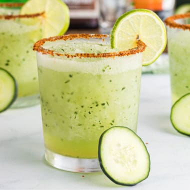 square image of cucumber margarita in a rocks glass with a lime