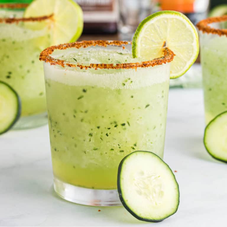 square image of cucumber margarita in a rocks glass with a lime