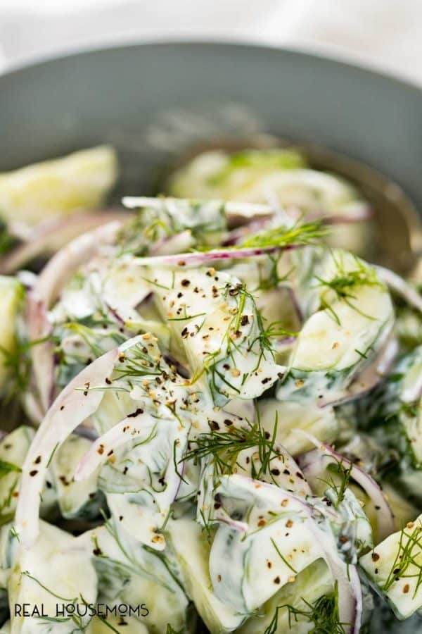 Close up of Cucumber Yogurt Dill Salad topped with more dill and freshly ground pepper