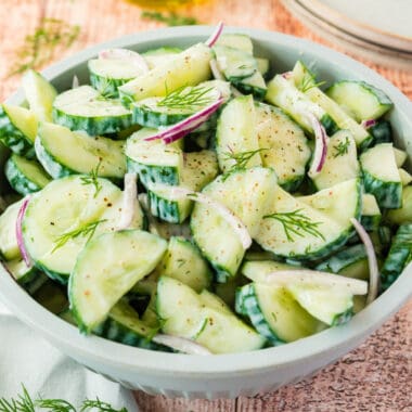 square image of cucumber yogurt dill salad in a serving bowl