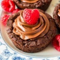 dark chocolate cookie cups topped with raspberries with recipe name at the bottom