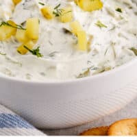side view of a bowl of dill pickle dip with recipe name at the bottom