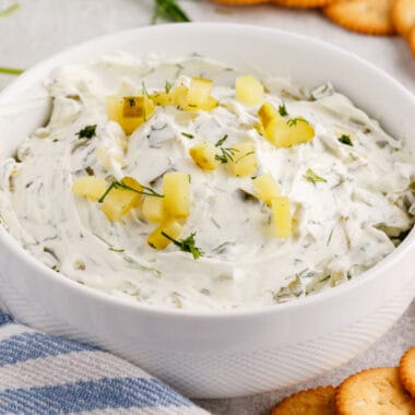 square image of dill pickle dip in a white bowl