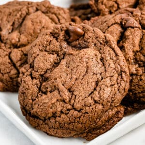 close up of adouble chocolate brownie cookie on a platter of cookies