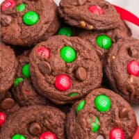square image of double chocolate chip M&M cookies piled up on a plate