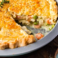 chicken pot pie with a slice taken out to show filling with recipe name at the bottom