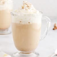 square image of a drunken pumpkin mocha in a glass mug with whipped cream