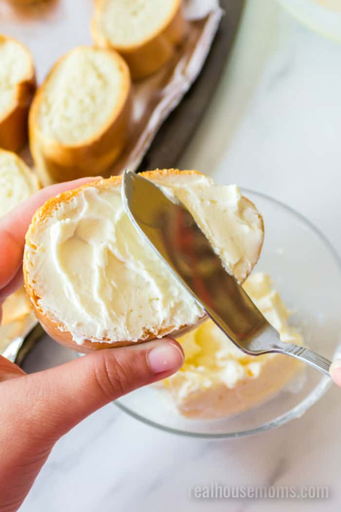 cream cheese being spread onto slices of bread