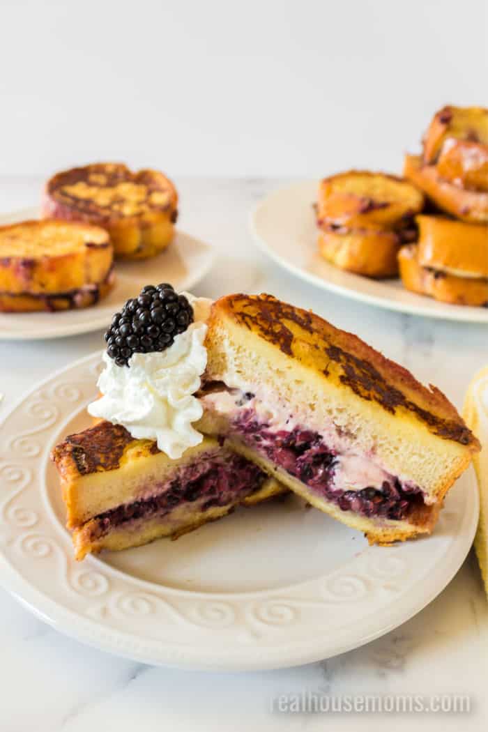 stuffed french toast with blackberries and cream cheese topped with whipped cream
