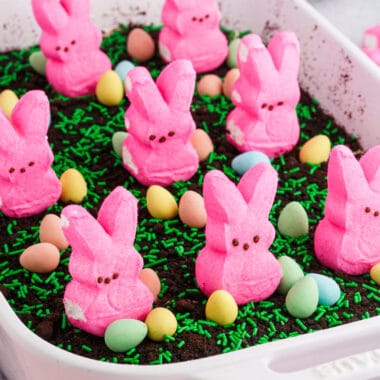 square image of easter dirt cakein a baking dish with peeps, candy eggs, and sprinkles on top
