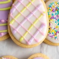 easter egg sugar cookies with different decorations on parchment paper with recipe name at bottom